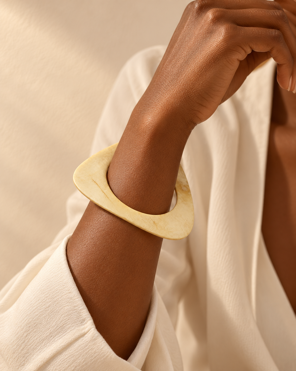 Mise en scène du bracelet Trocadéro ivoire porté au poignet, tenue écrue