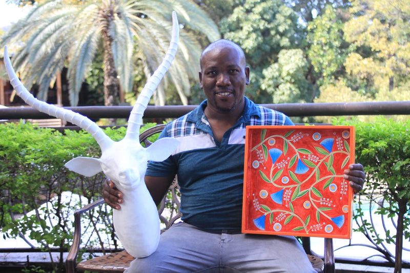 Émilien Blaise, artisan peintre à Jacmel, avec un plateau peint à la main